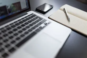 A modern workspace featuring a laptop, notebook, smartphone, and pen on a desk. jigsaw puzzle
