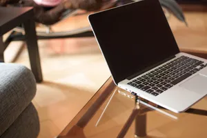 A sleek laptop on a glass table in a modern office setting, emphasizing technology and productivity. jigsaw puzzle