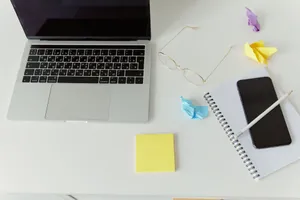 A minimalistic office desk with a laptop, notepad, and crumpled paper for productivity. jigsaw puzzle