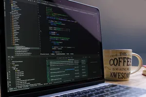 Close-up of laptop with coding software and a motivational coffee mug on a desk. jigsaw puzzle