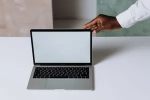 Laptop on a clean desk with a hand reaching towards it, perfect for business and technology themes. jigsaw puzzle