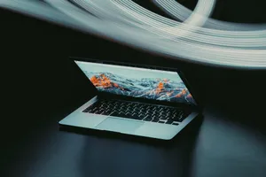 A partially open laptop on a table, illuminated by dynamic light trails, creating a modern tech ambiance. jigsaw puzzle