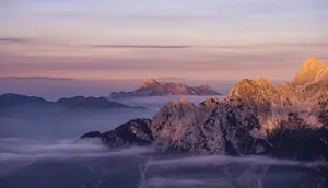 Beautiful mountain range with mist and soft sunrise hues, captured in a panoramic view. jigsaw puzzle