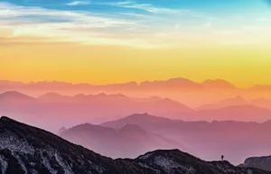 Colorful sunrise over misty mountains in Altmünster, Austria with a lone hiker silhouette. jigsaw puzzle