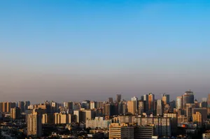 Panoramic view of a modern city skyline featuring skyscrapers under a clear blue sky. jigsaw puzzle