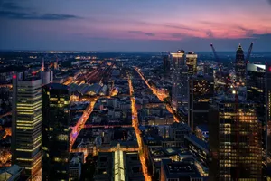 Aerial view of Frankfurt's modern skyline illuminated at dusk, showcasing the vibrant urban landscape. jigsaw puzzle