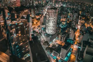 An aerial view of a bustling city at night showcasing illuminated skyscrapers and vibrant lights. jigsaw puzzle