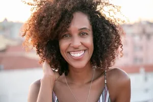 Happy woman with curly hair and brown eyes smiling outdoors. jigsaw puzzle