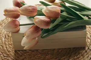 Elegant pink tulips resting on a book with a woven placemat backdrop, exuding a serene spring vibe. jigsaw puzzle