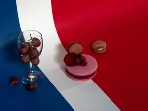 Colorful setup featuring grapes and macarons on a striped background. jigsaw puzzle