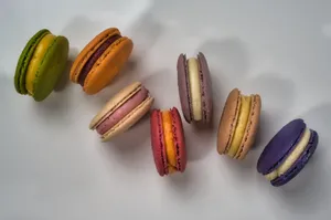 Vibrant assortment of colorful macarons on a white plate, showcasing diverse flavors. jigsaw puzzle