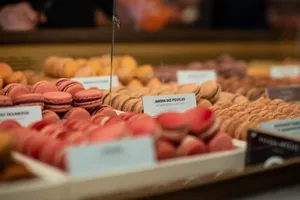 Vibrant macarons on display in a Paris market bakery, showcasing a variety of flavors. jigsaw puzzle