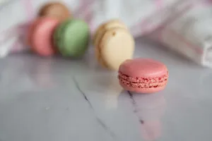 A close-up of assorted macarons on a marble surface, showcasing vibrant colors and textures. jigsaw puzzle
