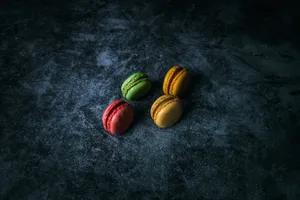 Top view of assorted colorful macarons on a dark textured surface. jigsaw puzzle