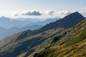 Captivating view of rugged mountains and rolling hills under a serene cloudy sky. jigsaw puzzle