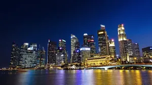 Vibrant night view of Singapore city skyline with illuminated skyscrapers reflected in water. jigsaw puzzle