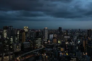 Dramatic Osaka skyline at twilight, showcasing illuminated skyscrapers against moody clouds. jigsaw puzzle