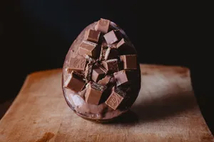 High angle of delicious sweet dessert with crispy chocolates and topping served in egg shaped  bowl and placed on wooden table jigsaw puzzle